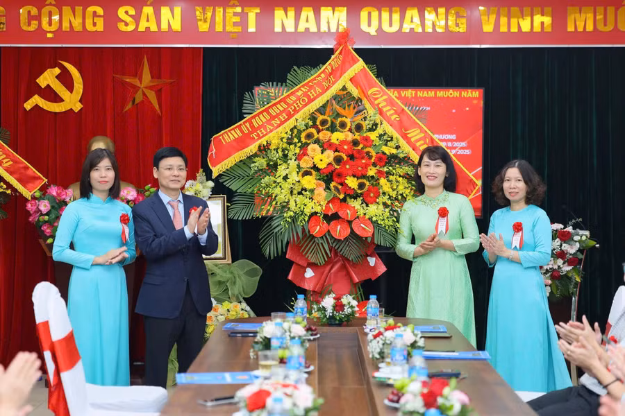 Phó Chủ tịch HĐND TP Hà Nội Phạm Quí Tiên tặng hoa và trao bằng công nhận cho Ban Giám hiệu Trường Tiểu học Nguyễn Tri Phương. Ảnh: TT