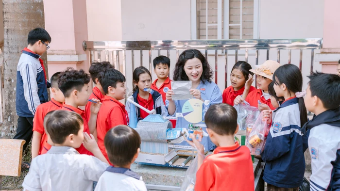 Học sinh trường Tiểu học và THCS Đồn Xá hào hứng tìm hiểu quy trình tái chế vỏ hộp sữa.