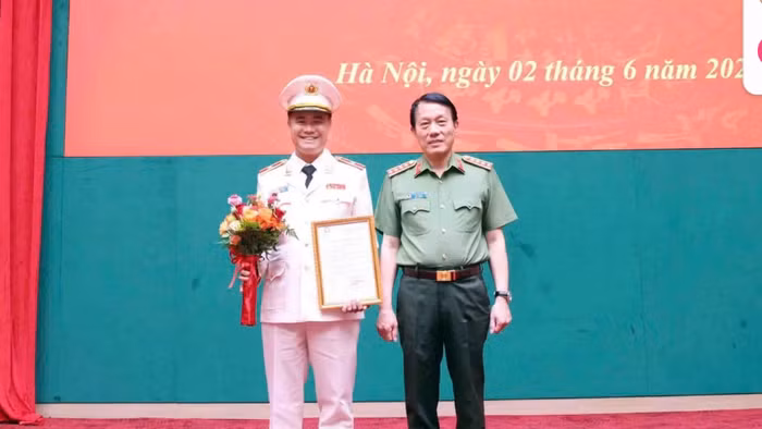 Đại tướng Lương Tam Quang, Bộ trưởng Bộ Công an trao Quyết định thăng cấp bậc hàm lên Thiếu tướng đối với Đại tá Nguyễn Ngọc Quyền (bên trái). Ảnh: Minh Đức.