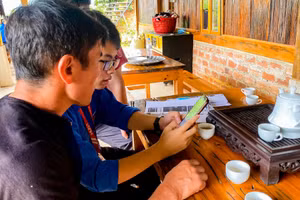 Sinh viên Khoa Khoa học và Công nghệ Giáo dục, Đại học Bách khoa Hà Nội hướng dẫn người dân ứng dụng công nghệ vào quản lý homestay và quảng bá văn hoá, du lịch địa phương.