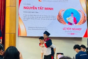 Ngô Văn Hiếu xuất hiện cõng Nguyễn Tất Minh lên nhận bằng tốt nghiệp. Ảnh: Ngô Chuyên.