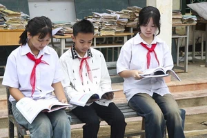 Học sinh Trường Phổ thông Dân tộc bán trú THCS Chiềng Sơ (xã Mường Luân) đọc sách giáo khoa mới. Ảnh: TTXVN.