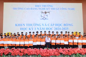 Ông Đặng An Bình, Hiệu trưởng Trường Cao đẳng Nghề Kỹ thuật Công nghệ trao học bổng cho học viên, sinh viên đạt loại khá, giỏi, xuất sắc. Ảnh Duy.