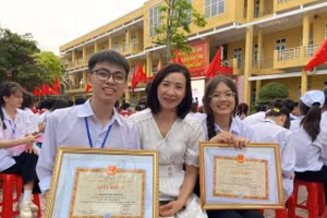 Phạm Việt Hoàng (bên trái) cùng cô giáo của mình.