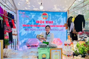 Chị Lò Chúc Chi, 22 tuổi, người dân tộc Thái, bản Bắc 2, xã Mường Lay, tỉnh Điện Biên bên gian hàng của HTX.