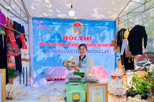 Chị Lò Chúc Chi, 22 tuổi, người dân tộc Thái, bản Bắc 2, xã Mường Lay, tỉnh Điện Biên bên gian hàng của HTX.