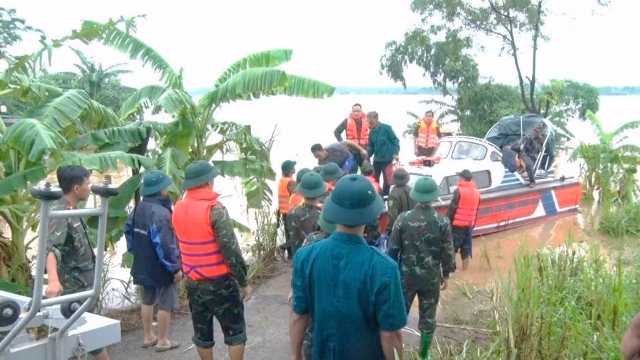 Lực lượng Công an, Quân đội huyện Cẩm Khê (Phú Thọ) hỗ trợ di dời người dân từ bãi bồi Phú Động, thị trấn Cẩm Khê đến khu vực an toàn.