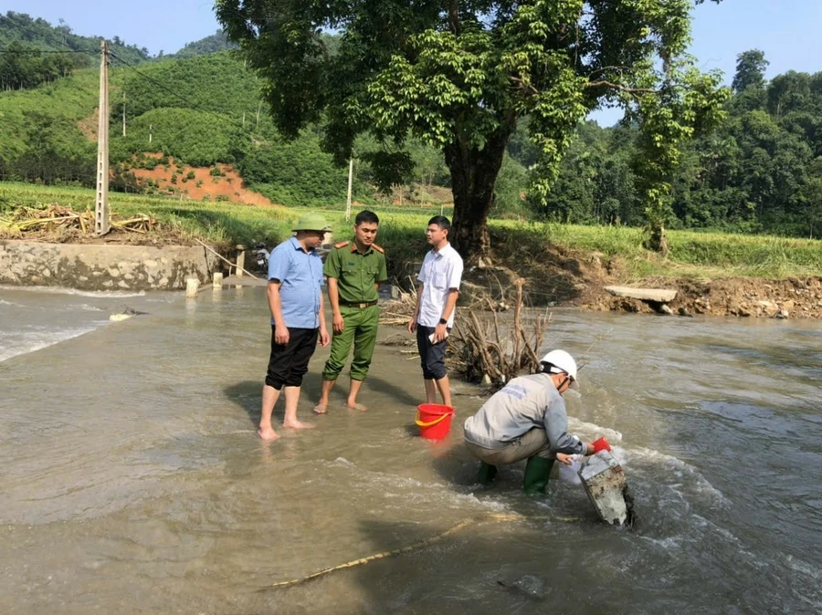 Cơ quan chức năng lấy mẫu xét nghiệm nước tại khu vực ảnh hưởng bởi sự cố. 