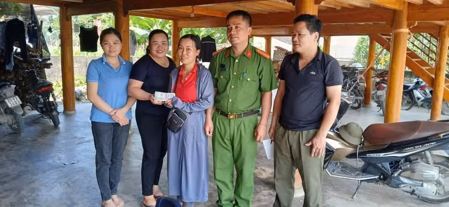 Chị Hiệp (áo đen) trao trả hơn 20 triệu đồng cho người đánh rơi. (Ảnh CA xã Minh Xuân).