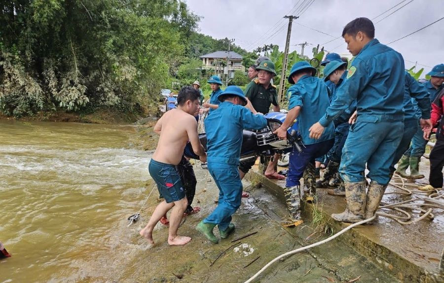 Lực lượng chức năng trục vớt xe máy của nạn nhân vụ nước lũ cuốn trôi.