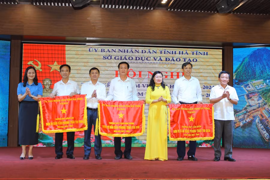 Lãnh đạo UBND tỉnh và Sở GD&ĐT Hà Tĩnh trao cờ thi đua của UBND tỉnh cho 3 đơn vị trường học.