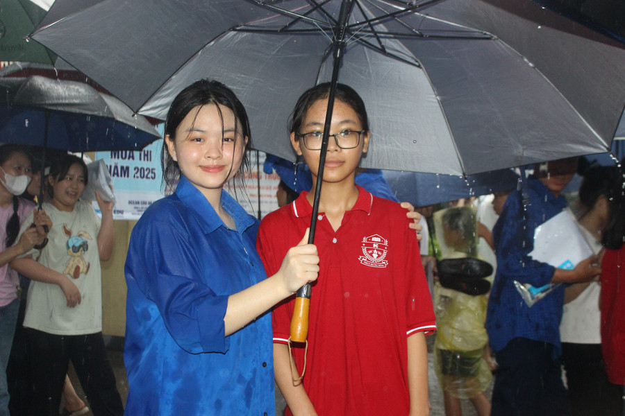 Ngay khi cổng hội đồng thi vừa mở, các tình nguyện viên đã đội mưa dùng ô hỗ trợ thí sinh ra xe. img-6656.jpg