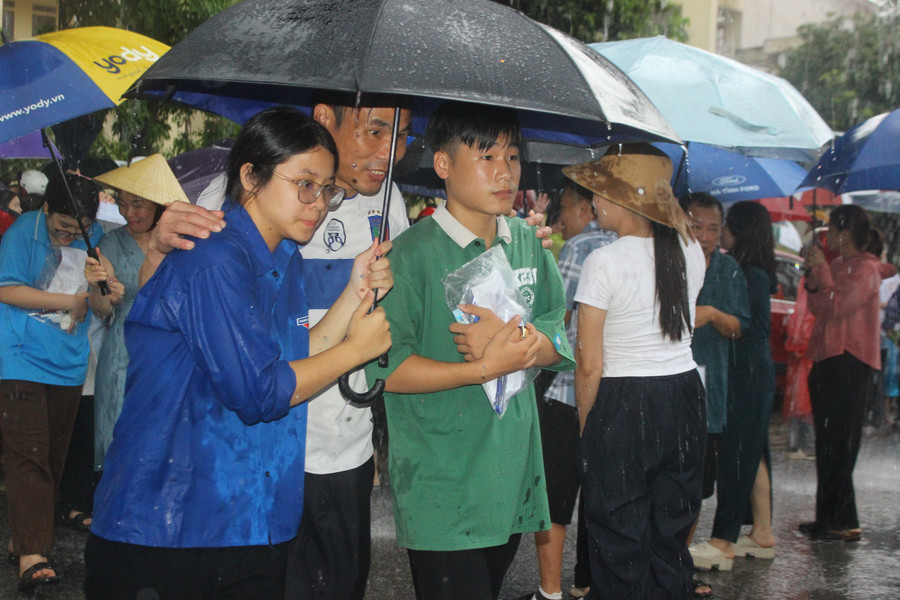 Nhiều phụ huynh không kịp đưa áo mưa, ô dù cũng được các tình nguyện viên nhiệt tình giúp đỡ. img-6663.jpg