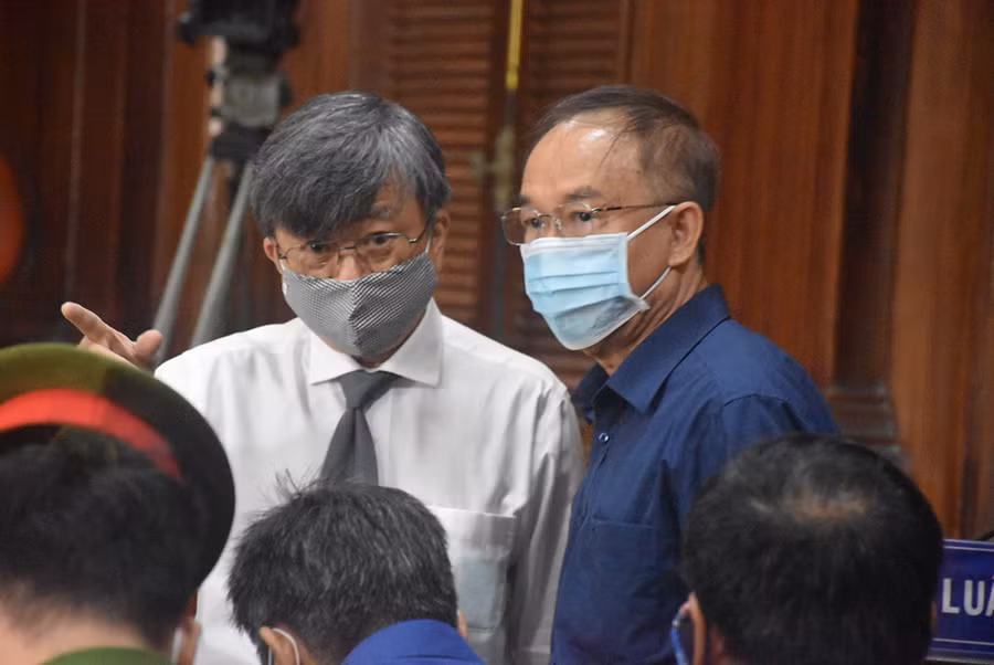 Ông Nguyễn Thành Tài trao đổi đổi với luật sư tại tòa. Ảnh: C.Chương