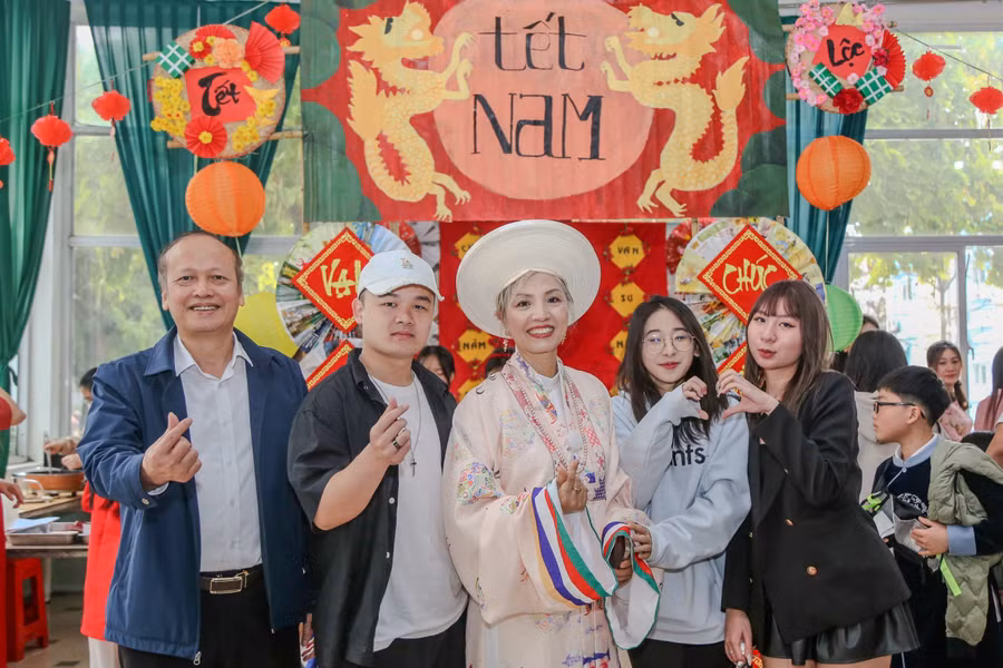 Bà Phạm Liên Hương - Giám đốc Trường Phổ thông Quốc tế Kinh Bắc (đứng giữa) lưu lại hình ảnh với giáo viên và học trò tại gian hàng chợ Tết.