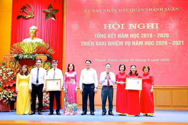 Ông Phạm Văn Đại - Phó Giám đốc Sở GD&ĐT Hà Nội tặng Huân chương Lao động Hạng Nhì cho tập thể phòng GD&ĐT và trường Tiểu học Khương Mai.