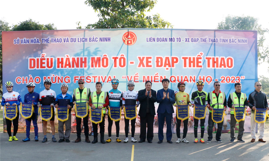 Ban tổ chức trao cờ lưu niệm cho đại diện các câu lạc bộ tham gia diễu hành mô tô - xe đạp.