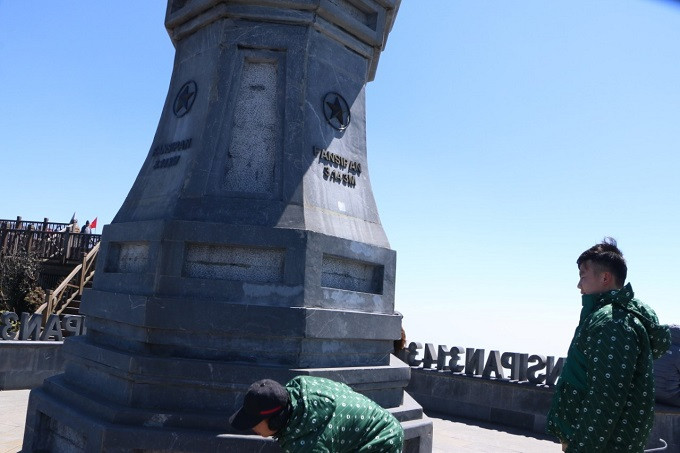 Cán bộ kỹ thuật hạ tầng của Sun World Fansipan Legend xử lý dòng chữ khắc tại chân cột cờ