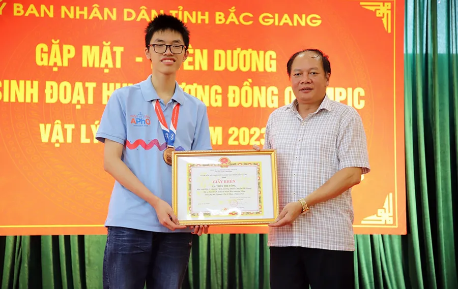 Em Thân Thế Công (bên trái) trong lần nhận khen thưởng từ Giám đốc Sở GD&ĐT tỉnh Bắc Giang.