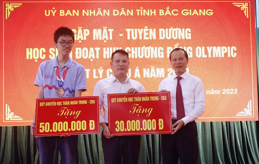 Em Thân Thế Công và thầy Nguyễn Văn Đóa nhận phần thưởng từ Quỹ Khuyến học Thân Nhân Trung.