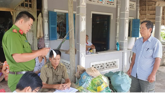 Đại diện Công an huyện.U Minh Thượng đọc quyết định xử phạt hành chính ông Nguyễn Văn Hùng (đứng bên phải) vì có hành vi báo tin giả.