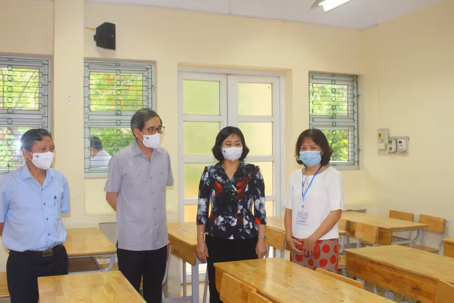 Bà Nguyễn Thị Tuyến nhắc nhở điểm thi tại Trường THPT Phạm Hồng Thái triển khai kê bàn ghế đảm bảo giãn cách phòng dịch cho thí sinh dự thi.