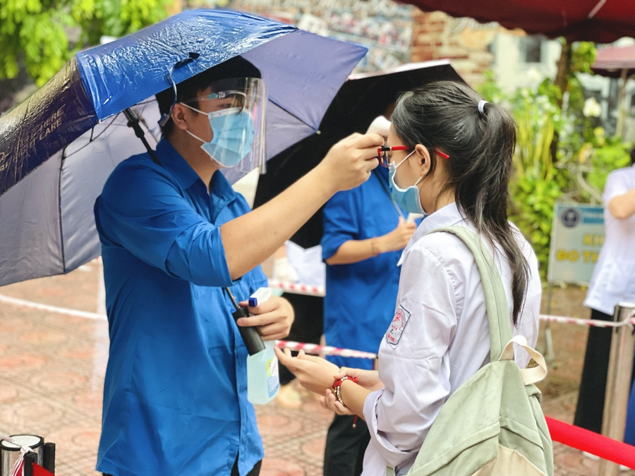 Đo thân nhiệt tại điểm thi Trường THCS Ba Đình (quận Ba Đình).