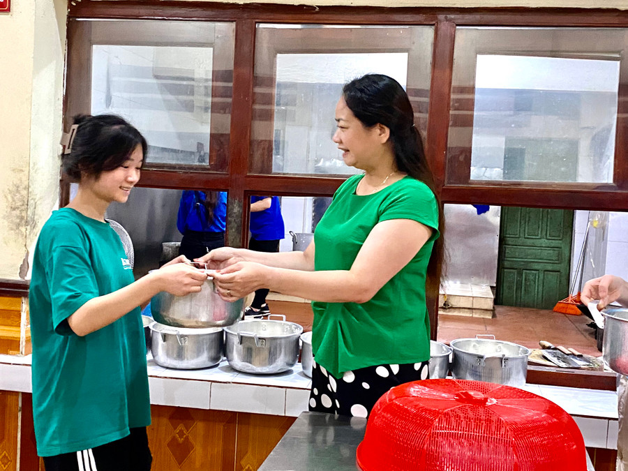 Cô Lương Ngọc Thanh - Phó Hiệu trưởng Trường THPT DTNT Lạng Sơn phát cháo cho học sinh. Ảnh Ngô Chuyên.