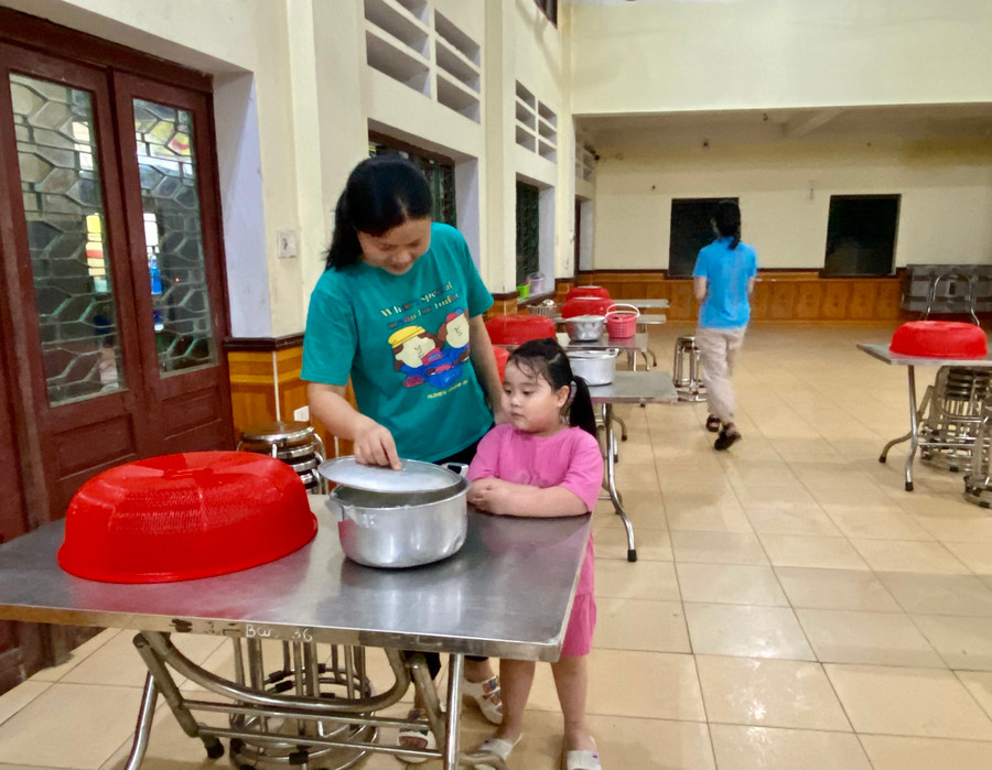 Cô giáo có con nhỏ dẫn theo đến trường để nấu cháo. Ảnh Ngô Chuyên.