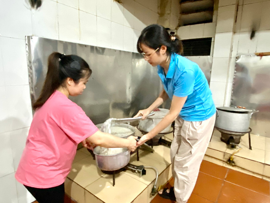 Cô Chu Thị Luyện (áo hồng) - Phó bí thư đoàn thanh niên mang bầu không thể đi trông thi đã tham gia cùng đồng nghiệp ở lại hỗ trợ nấu cháu, tiếp sức cho học sinh. Ảnh Ngô Chuyên.