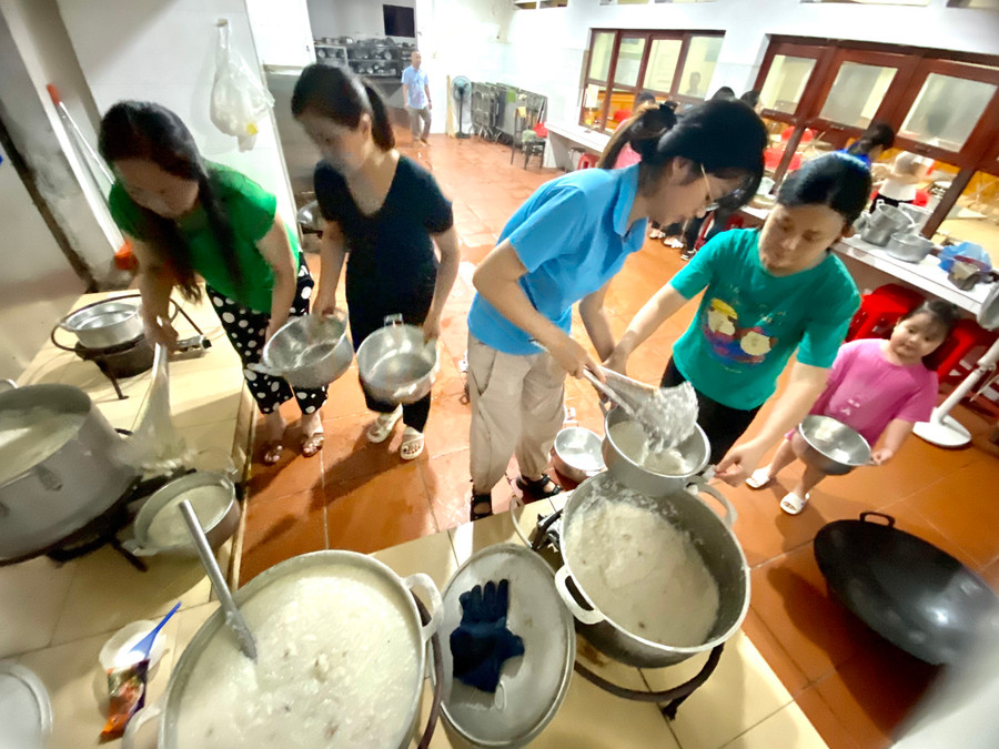 Các giáo viên múc cháo chia thành những nồi nhỏ để chuẩn bị gọi học sinh ăn khuya. Ảnh Ngô Chuyên.