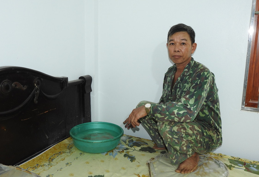 Ông Doanh phải dùng chậu đặt trên giường để hứng nước do trần nhà bị dột. Ông Doanh phải dùng chậu đặt trên giường để hứng nước do trần nhà bị dột.