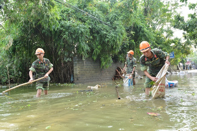 Cán bộ, chiến sĩ giúp nhân dân tổng dọn vệ sinh môi trường.