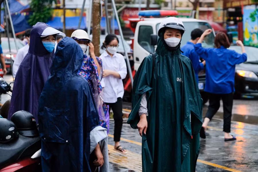 Phụ huynh dưới mưa tại cổng Điểm thi trường THPT Ngô Sĩ Liên (thành phố Bắc Giang).