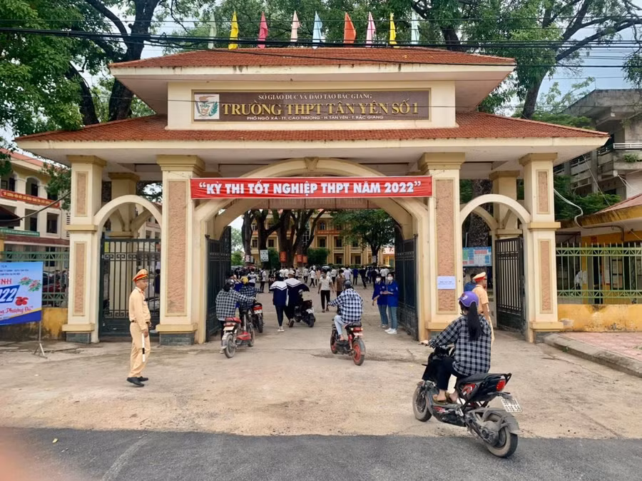 Tình nguyện viên cùng Cảnh sát giao thông phân luồng đảm bảo ATGT trước cổng Điểm thi trường THPT Tân Yên số 1.