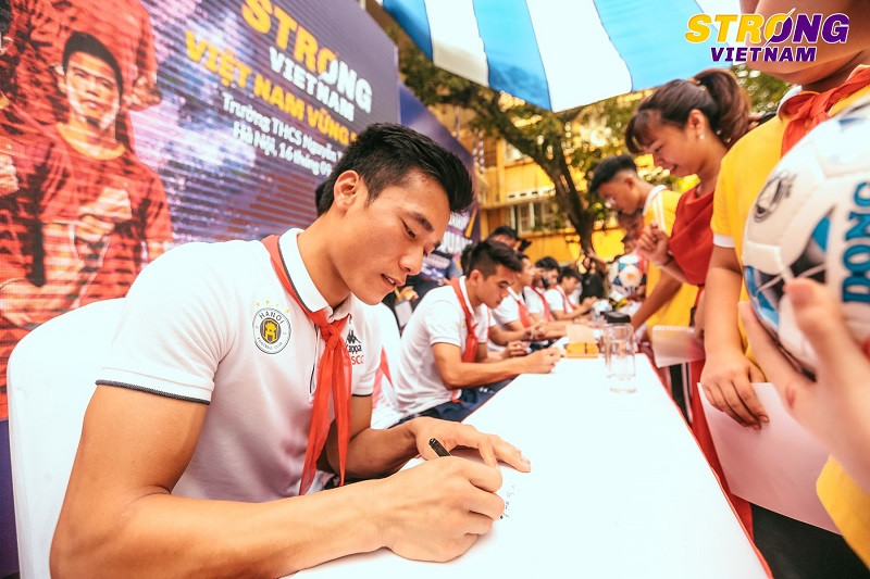 Các cầu thủ ký tặng các em học sinh trường THCS Nguyễn Trường Tộ