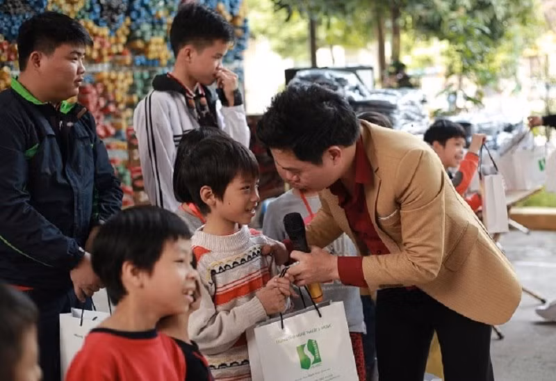 Ca sĩ Đào Tiến Lợi tặng quà cho các em học sinh nghèo vùng cao.