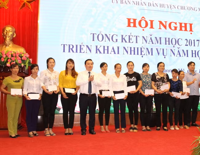 Ông Chử Xuân Dũng- Giám đốc Sở GD&ĐT Hà Nội trao số tiền hỗ trợ các thầy cô gặp nhiều khó khăn do ảnh hưởng ngập lụt ở huyện Chương Mỹ