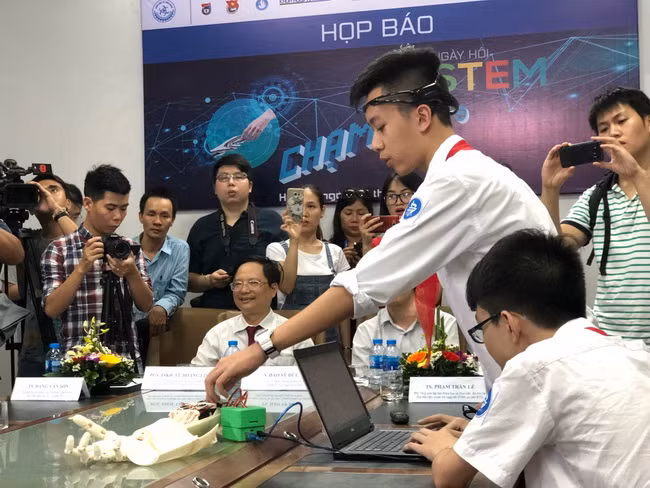 Học sinh trường THCS Trưng Vương (Hà Nội) trình diễn cánh tay robot điều khiến bằng suy nghĩ.