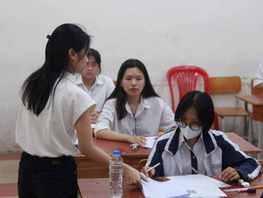 Cán bộ coi thi phát giấy nháp thi cho thí sinh.