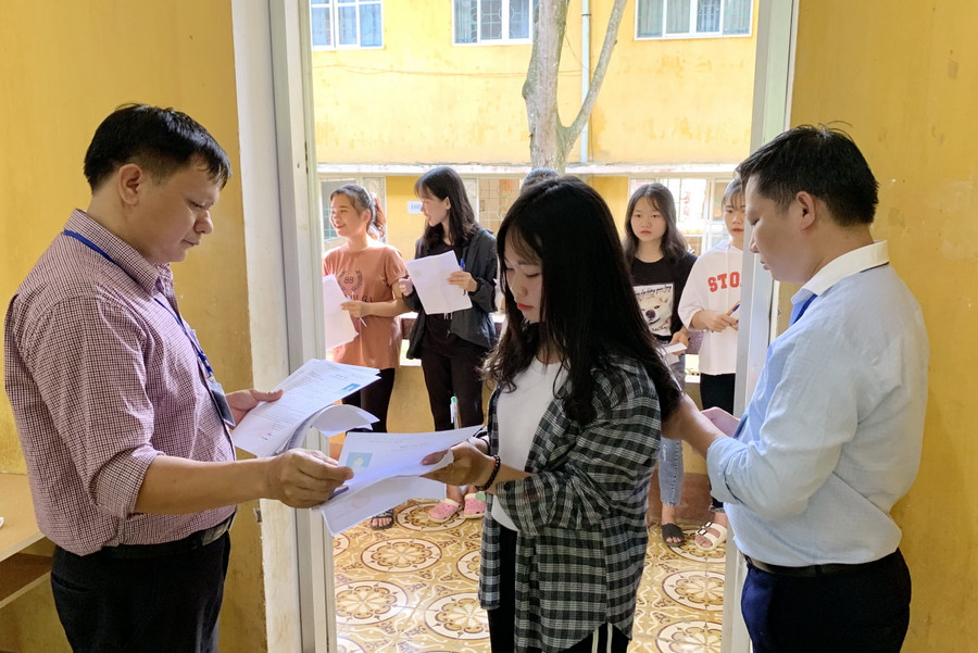 Cán bộ coi thi gọi thí sinh vào phòng thi.