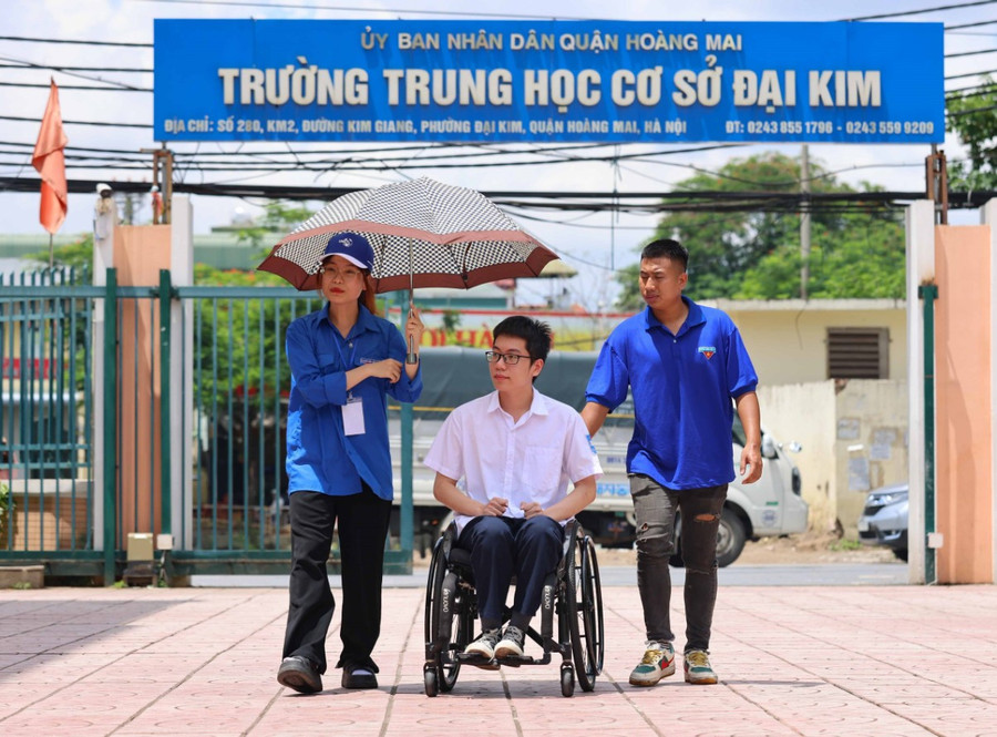 Thí sinh được các tình nguyện viên hỗ trợ vào phòng thi. Ảnh: Thanh Tùng.