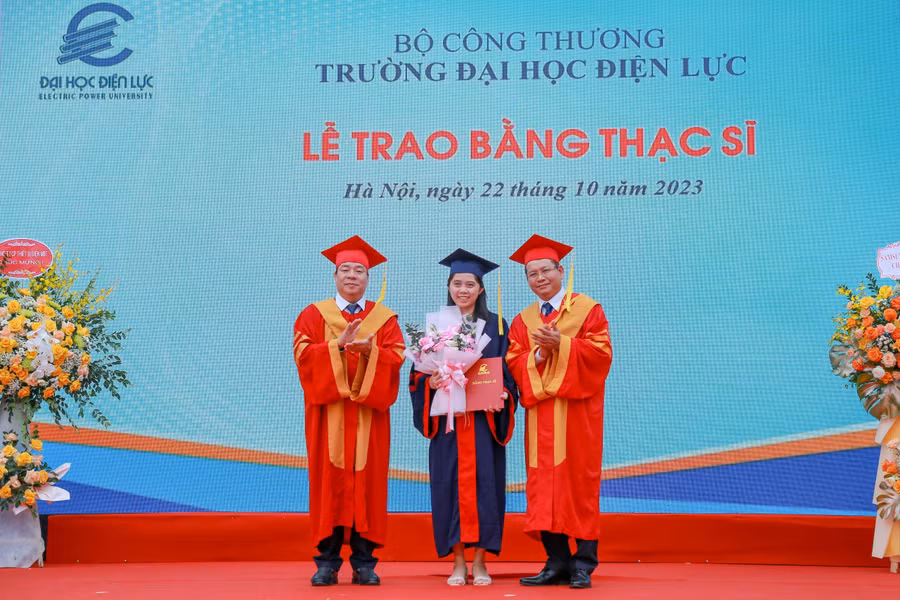 PGS.TS Vũ Đình Ngọ - Chủ tịch Hội đồng trường (bên trái) và PGS.TS Đinh Văn Châu - Quyền Hiệu trưởng trường Đại học Điện lực trao bằng tốt nghiệp và chúc mừng tân thạc sĩ.