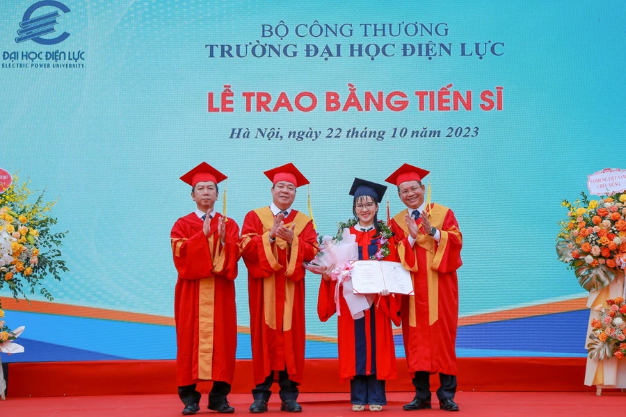 PGS.TS Vũ Đình Ngọ - Chủ tịch Hội đồng trường (thứ 2 từ trái sang) và PGS.TS Đinh Văn Châu - Quyền Hiệu trưởng trường Đại học Điện lực trao bằng tốt nghiệp và chúc mừng tân Tiến sĩ. 