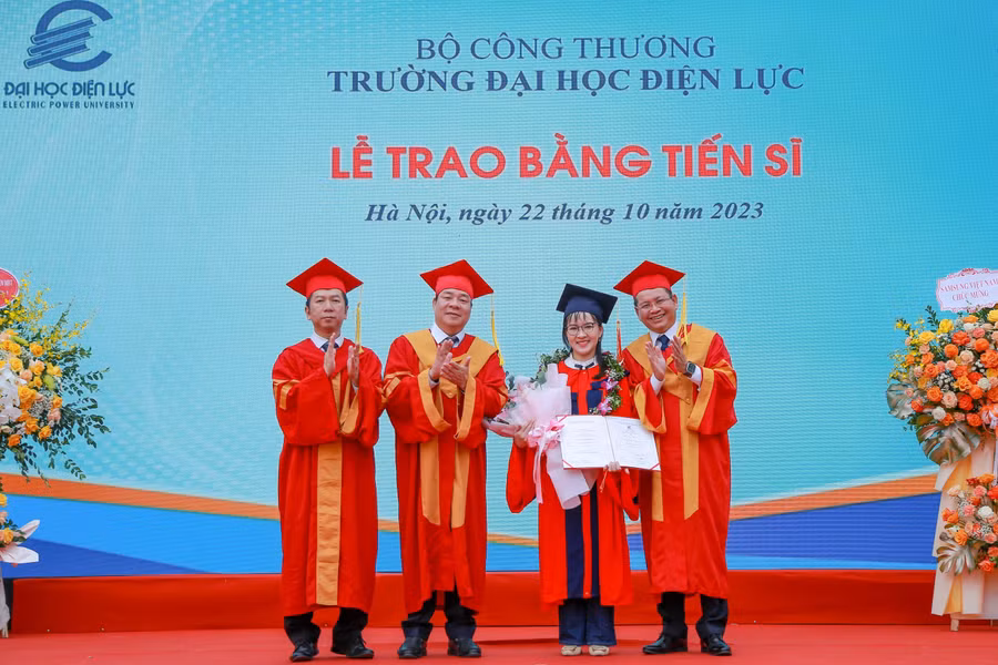 PGS.TS Vũ Đình Ngọ - Chủ tịch Hội đồng trường (thứ 2 từ trái sang) và PGS.TS Đinh Văn Châu - Quyền Hiệu trưởng trường Đại học Điện lực trao bằng tốt nghiệp và chúc mừng tân Tiến sĩ. 