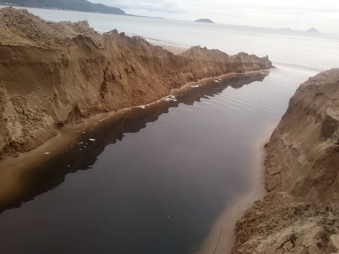 Dòng nước thải đen ngòm bốc mùi hôi thối còn đọng lại trên bãi cát.Ảnh Mạnh Tuấn Dòng nước thải đen ngòm bốc mùi hôi thối còn đọng lại trên bãi cát.Ảnh Mạnh Tuấn