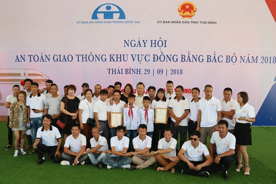 Đại diện Uỷ ban ATGT Quốc gia trao mũ bảo hiểm cho các em học sinh. Ảnh: VGP