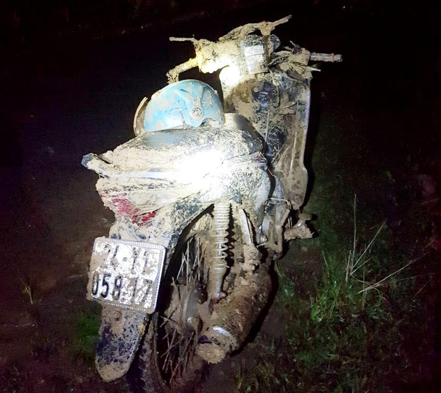 Chiếc xe máy chở hai bà cháu bị vùi lấp, được người dân tìm thấy trong khối đất sạt lở.