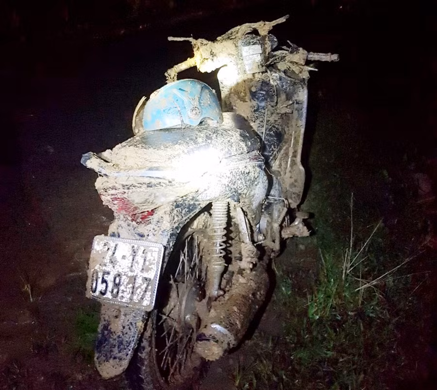 Chiếc xe máy chở hai bà cháu bị vùi lấp, được người dân tìm thấy trong khối đất sạt lở.