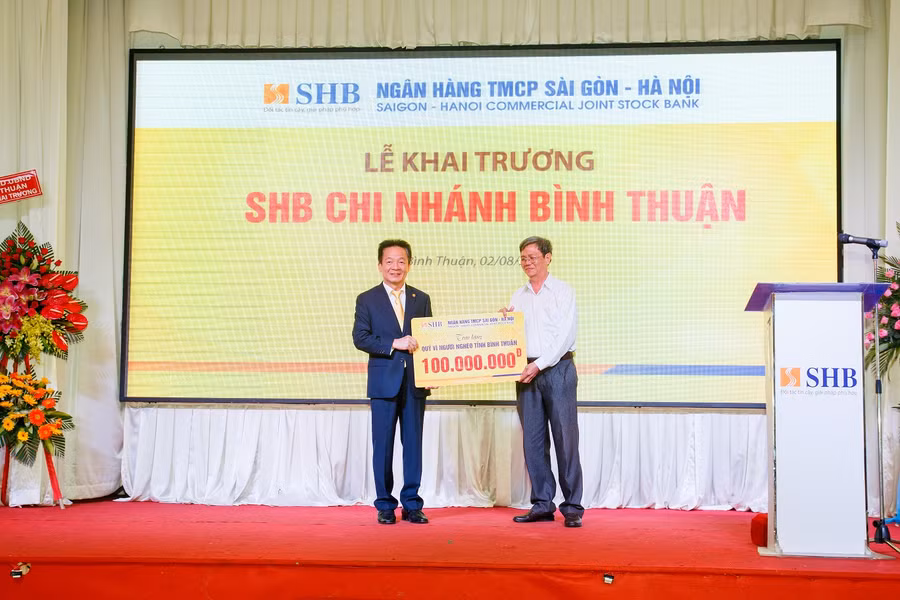 Ông Nguyễn Văn Nam – Phó Chủ tịch UBMTTQ Việt Nam (bên phải) nhận món quà từ ông Đỗ Quang Hiển – Chủ tịch HĐQT SHB ủng hộ Quỹ vì người nghèo tỉnh Bình Thuận.